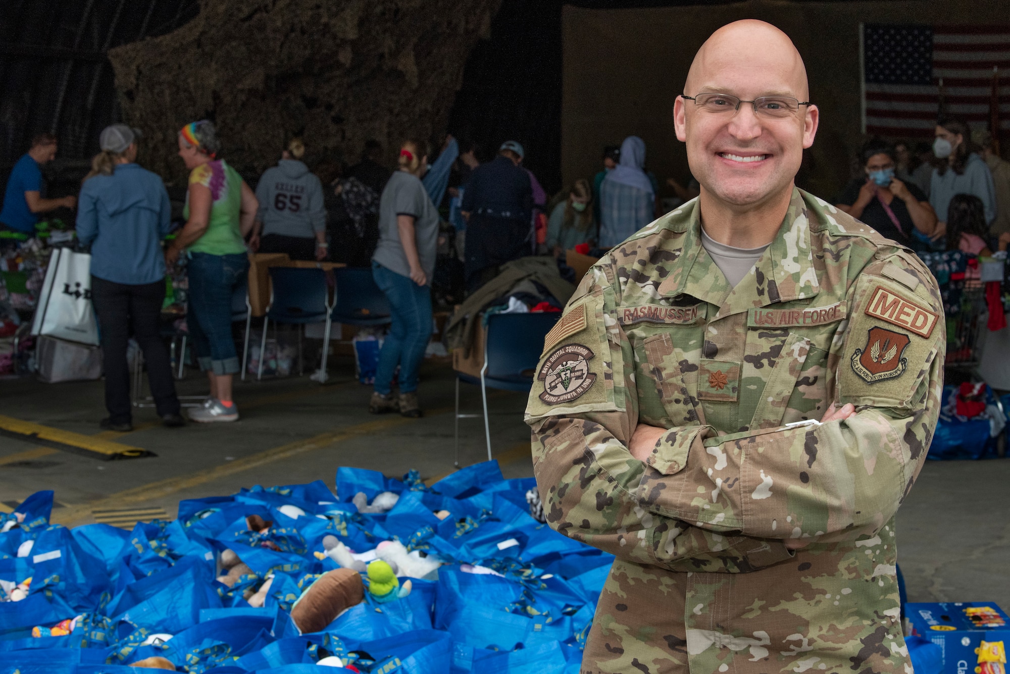 Volunteer poses in front of donations.