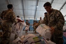 210828-N-ZA692-1277 U.S. service members deliver supplies in support of U.S. citizens and evacuees arriving from Afghanistan at a location in the U.S. 5th Fleet area of operations prior to onward travel to the United States. The U.S. 5th Fleet region encompasses nearly 2.5 million square miles of water area and is comprised of 20 countries. (U.S. Navy photo by Mass Communication Specialist 2nd Class Anita Chebahtah)