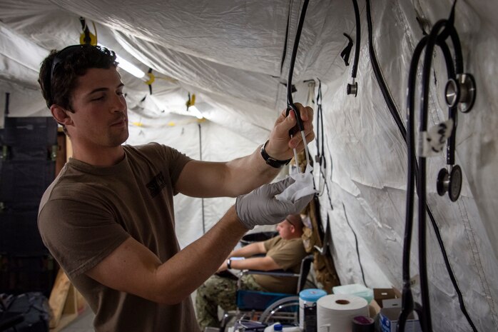 210823-N-ZA692-0034 U.S. 5TH FLEET AREA OF OPERATIONS (Aug. 23, 2021) – A U.S. service member sanitizes medical supplies while assisting U.S. citizens and evacuees arriving from Afghanistan at a location in the U.S. 5th Fleet area of operations prior to onward travel to the United States. The U.S. 5th Fleet region encompasses nearly 2.5 million square miles of water area and is comprised of 20 countries. (U.S. Navy photo by Mass Communication Specialist 2nd Class Anita Chebahtah)