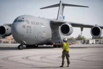 210823-N-ZA692-0081 U.S. 5TH FLEET AREA OF OPERATIONS (Aug. 23, 2021) – A U.S. Air Force C-17 Globemaster III loadmaster taxies on the runway carrying U.S. citizens and evacuees from Afghanistan at a location in the U.S. 5th Fleet area of operations prior to onward travel to the United States. The U.S. 5th Fleet region encompasses nearly 2.5 million square miles of water area and is comprised of 20 countries. (U.S. Navy photo by Mass Communication Specialist 2nd Class Anita Chebahtah)