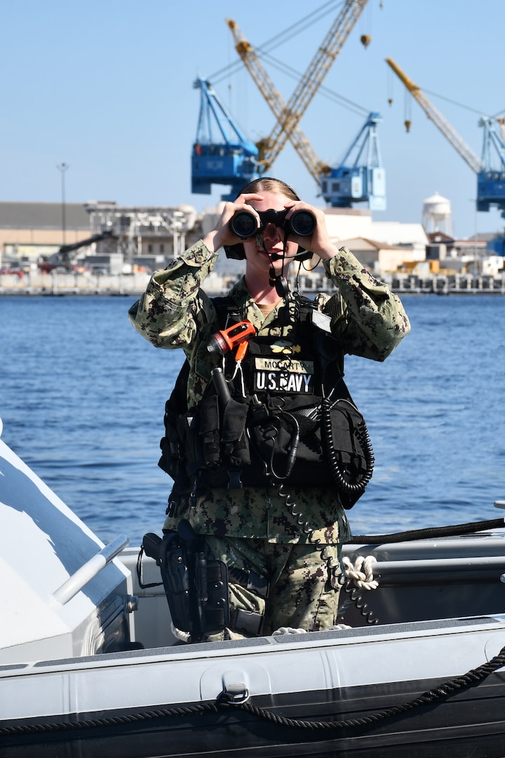 Master-at-Arms Seaman Lauren McCarty scans the area looking for potential threats. Above: NNSY security boats patrol their area of operation.
