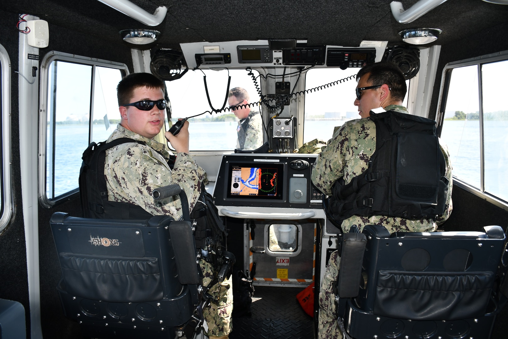 Master-at-Arms Second Class Brandon Spears and Master-at-Arms Third Class Evan Shankle works together as a team as they maneuver a security boat.