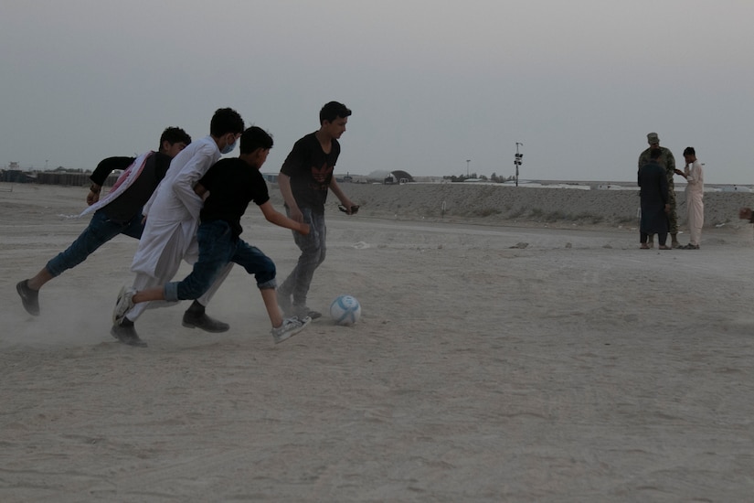 A group of Afghan evacuees play an evening pick-up soccer match at Camp Buehring, Kuwait, Aug. 25, 2021. U.S. Soldiers welcomed Afghan evacuees to the facility with open arms, providing a variety of support, to include recreation and activities, to ease the process. (U.S. Army photo by Sgt. Marc Loi)