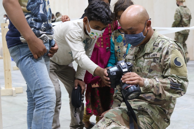 A U.S. Army National Guard Soldier with Task Force Spartan, U.S. Army Central shares photos he’s taken with Afghan evacuees during the arrival process at Camp Buehring, Kuwait, Aug. 25, 2021. USARCENT Soldiers from all components are supporting Afghanistan evacuation efforts in a variety of ways to include capturing photos of the many moments of care and compassion. (U.S. Army photo by Pfc. Katelynn Bissell)