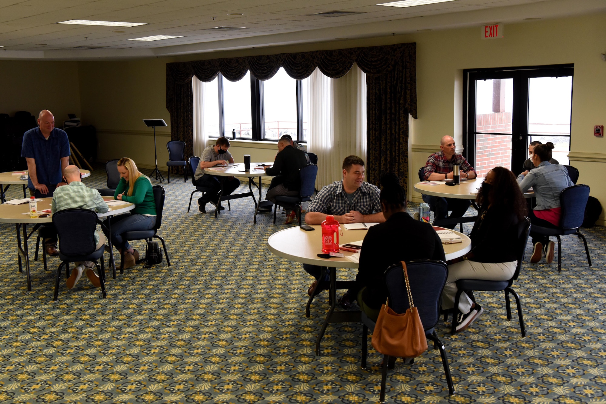 Men and women sit around tables.