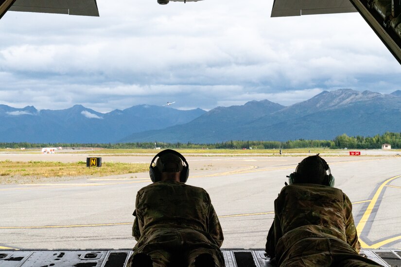U.S. Air Force Staff Sgt. Nolan Brant, a 39th Airlift Squadron C-130J Super Hercules instructor loadmaster from Dyess Air Force Base, Texas, and Airman 1st Class Andrew Harris, a 39th Airlift Squadron C-130J Super Hercules loadmaster from Dyess AFB, Texas, view the flight line as the plane taxis for takeoff.