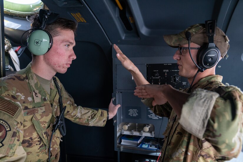 U.S. Air Force Airman 1st Class Andrew Harris, a 39th Airlift Squadron C-130J Super Hercules loadmaster from Dyess Air Force Base, Texas, and Staff Sgt. Nolan Brandt, a 39th Airlift Squadron C-130J Super Hercules instructor loadmaster from Dyess AFB, Texas, discuss flight maneuvers during a RED FLAG-Alaska 21-3 sortie.
