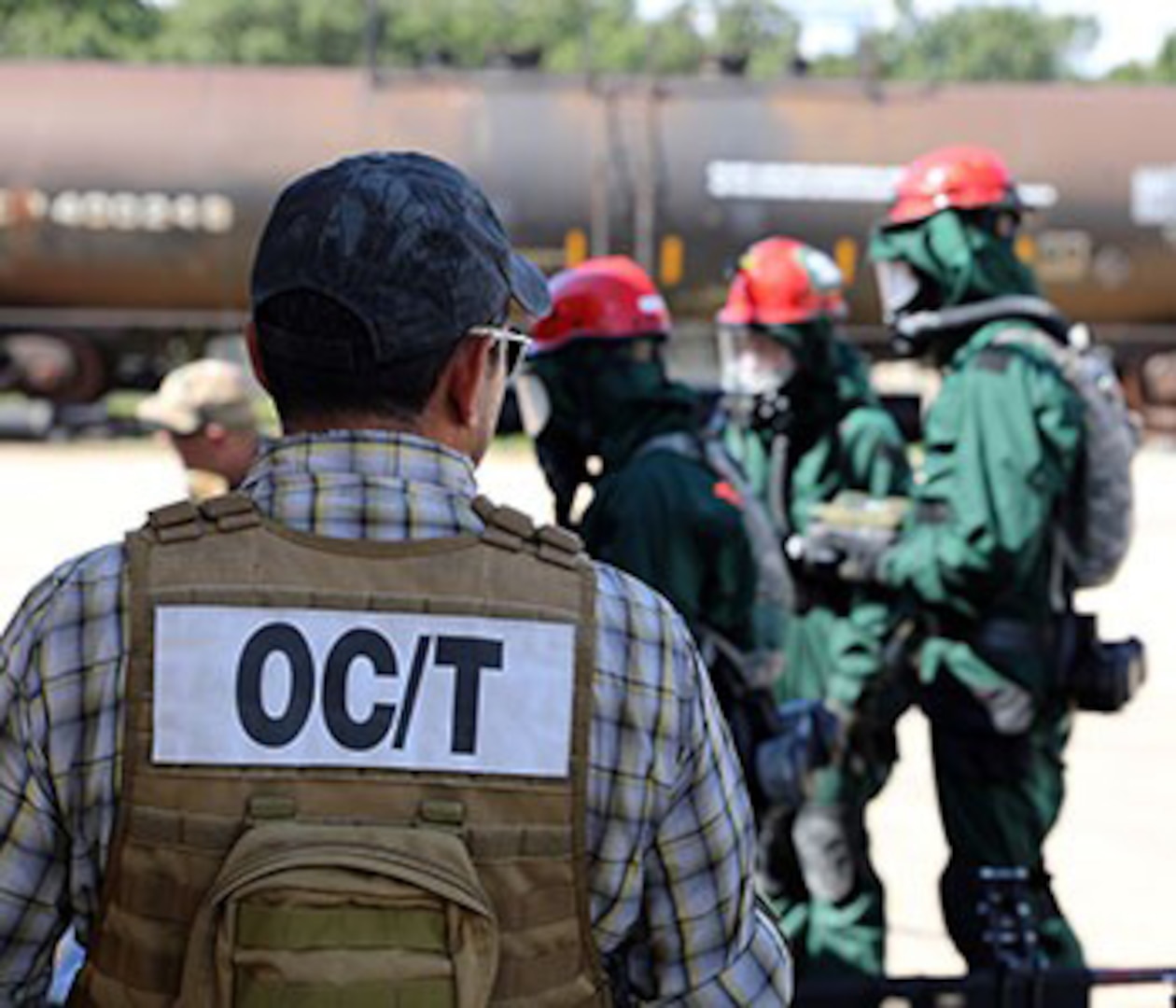 An evaluator looks on as members of the Wisconsin National Guard Chemical Biological Radiological Nuclear Enhanced Response Force Package (CERF-P) conduct a search and extraction mission Aug. 17, 2021, at Volk Field, Wis. The CERF-P is evaluated every two years to maintain and validate its readiness.