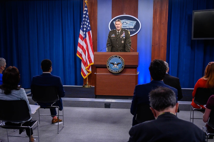 An Army general speaks from a podium with a Pentagon sign hanging behind him.