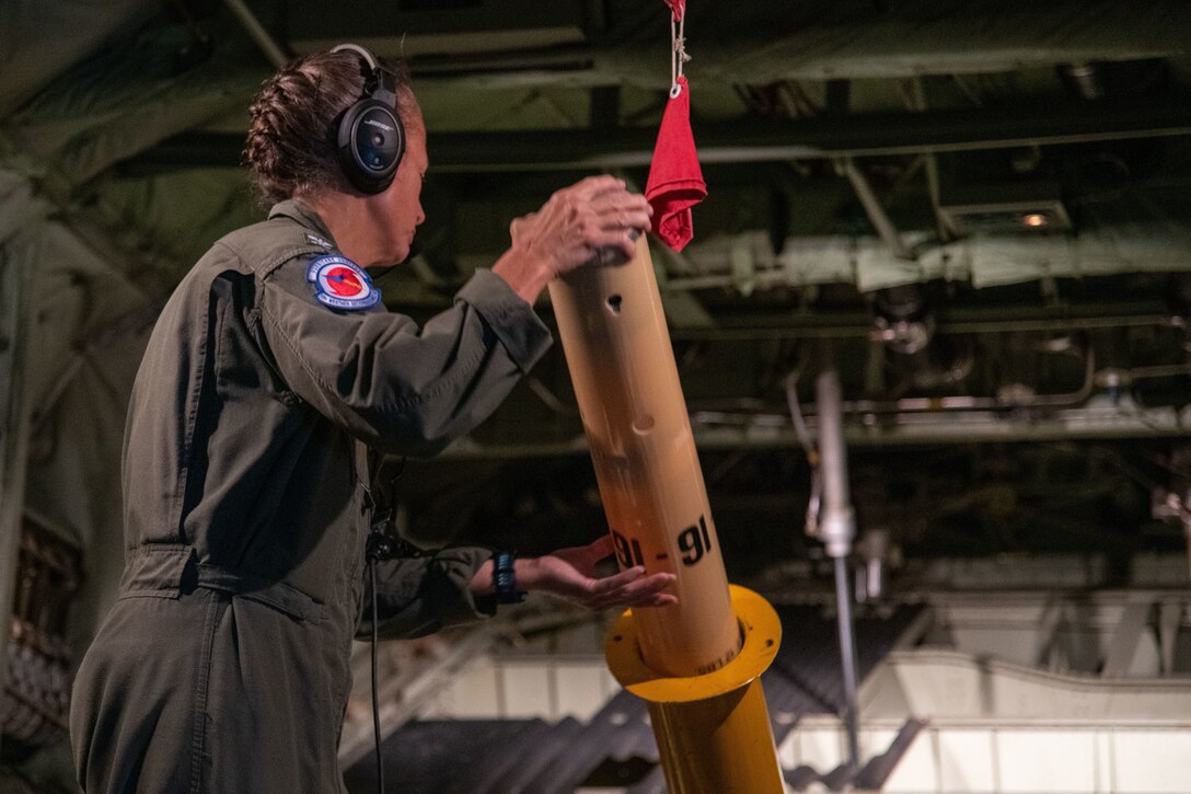 U.S. Navy Capt. (Dr.) Beth Sanabia, instructor of oceanography at the U.S. Naval Academy, loads an Airborne eXpendable Bathythermograph for launch during a flight into Hurricane Ida Aug. 29, 2021. Each summer, Sanabia and midshipmen from the USNA, as well as personnel from the Woods Hole Oceanographic Institute participate in an internship studying the ocean’s temperatures ahead of tropical systems. (U.S. Air Force photo by Staff Sgt. Kristen Pittman)