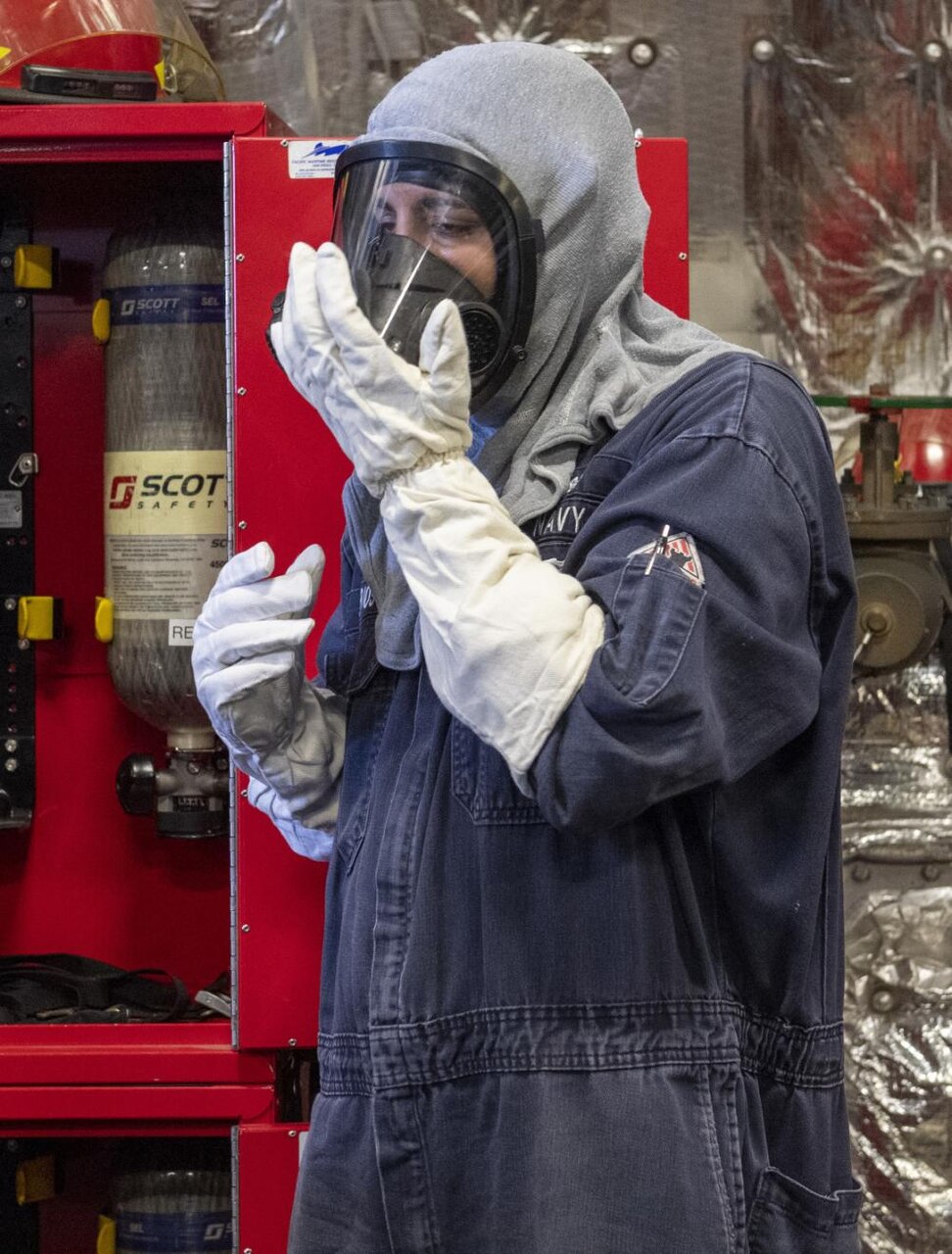 USS Jackson (LCS 6) Sailors put on fire fighting gear