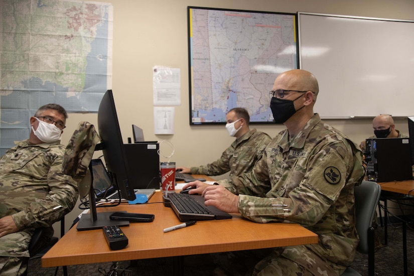 Soldiers work on laptops.