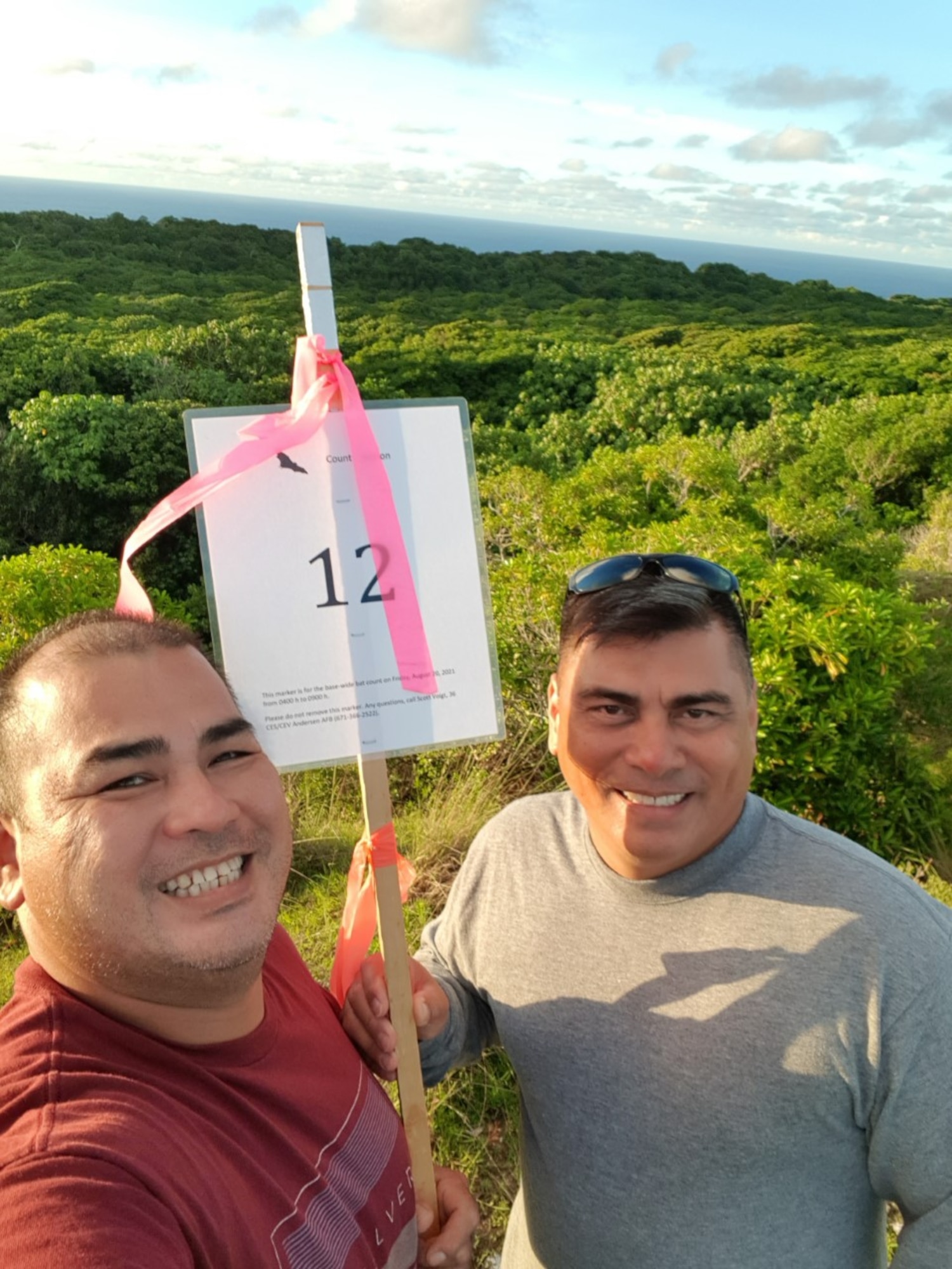 James Lewis and Jacob SanNicolas, 2021 Annual Fruit Bat Survey volunteers, take a photo at their station during the survey at Andersen Air Force Base, Guam, Aug. 20, 2021. Among agencies, community members and volunteers from 21 different organizations on base, 89 participants were able to participate in the survey and add to historical data that has been collected to help the endangered fanihi, a fruit bat that is endemic to the Mariana Islands. Observers were teamed among offices as part of COVID-19 mitigation measures.  (Courtesy photo)