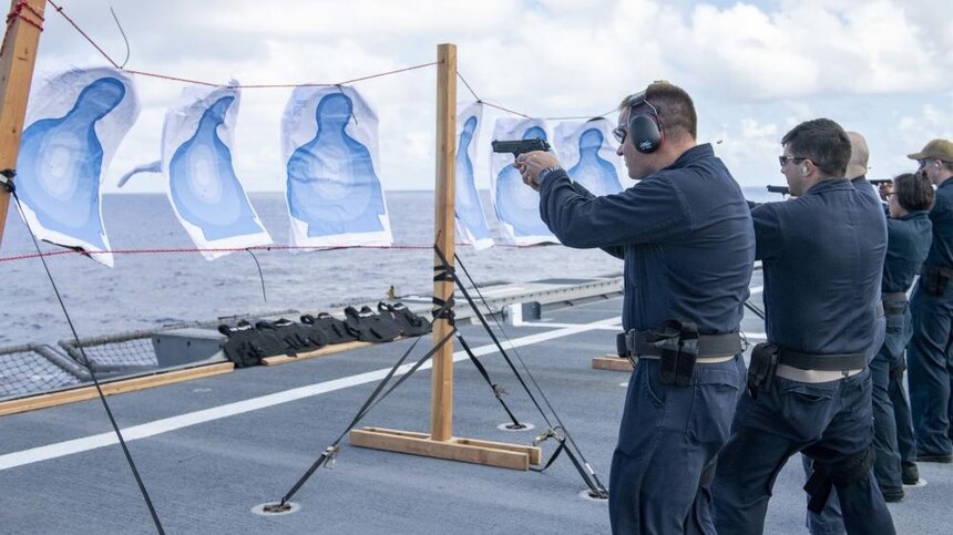 210827-N-WU807-1079 PHILIPPINE SEA (Aug. 27, 2021) Sailors train using pistols during small arms training aboard Independence-variant littoral combat ship USS Charleston (LCS 18), Aug. 27.