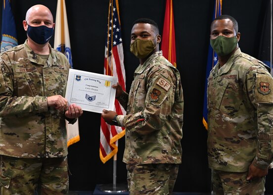 A selectee receives his promotion certificate from the 17th Training Wing commander.