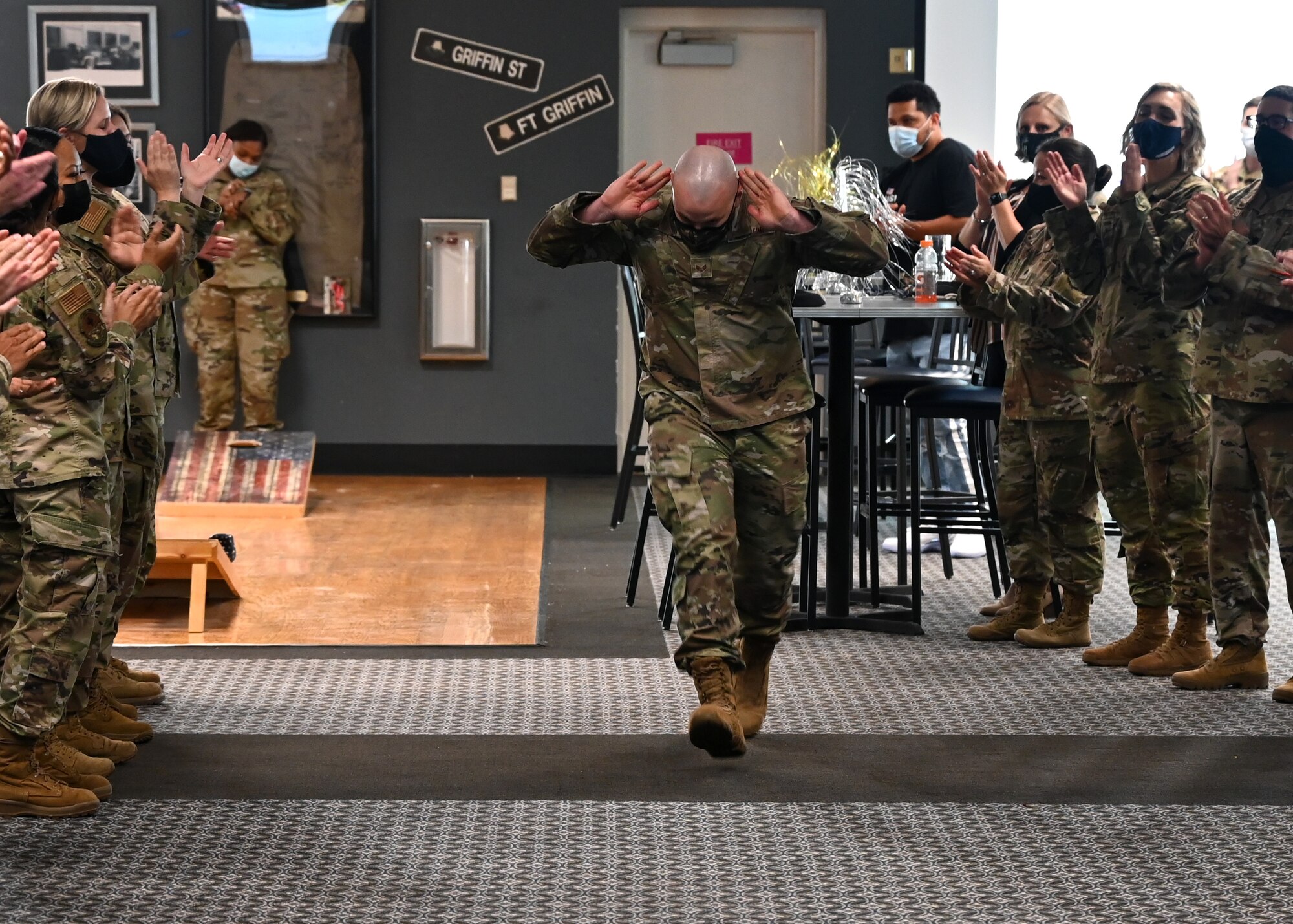 An Airman runs down "the gauntlet" to receive his promotion certificate.
