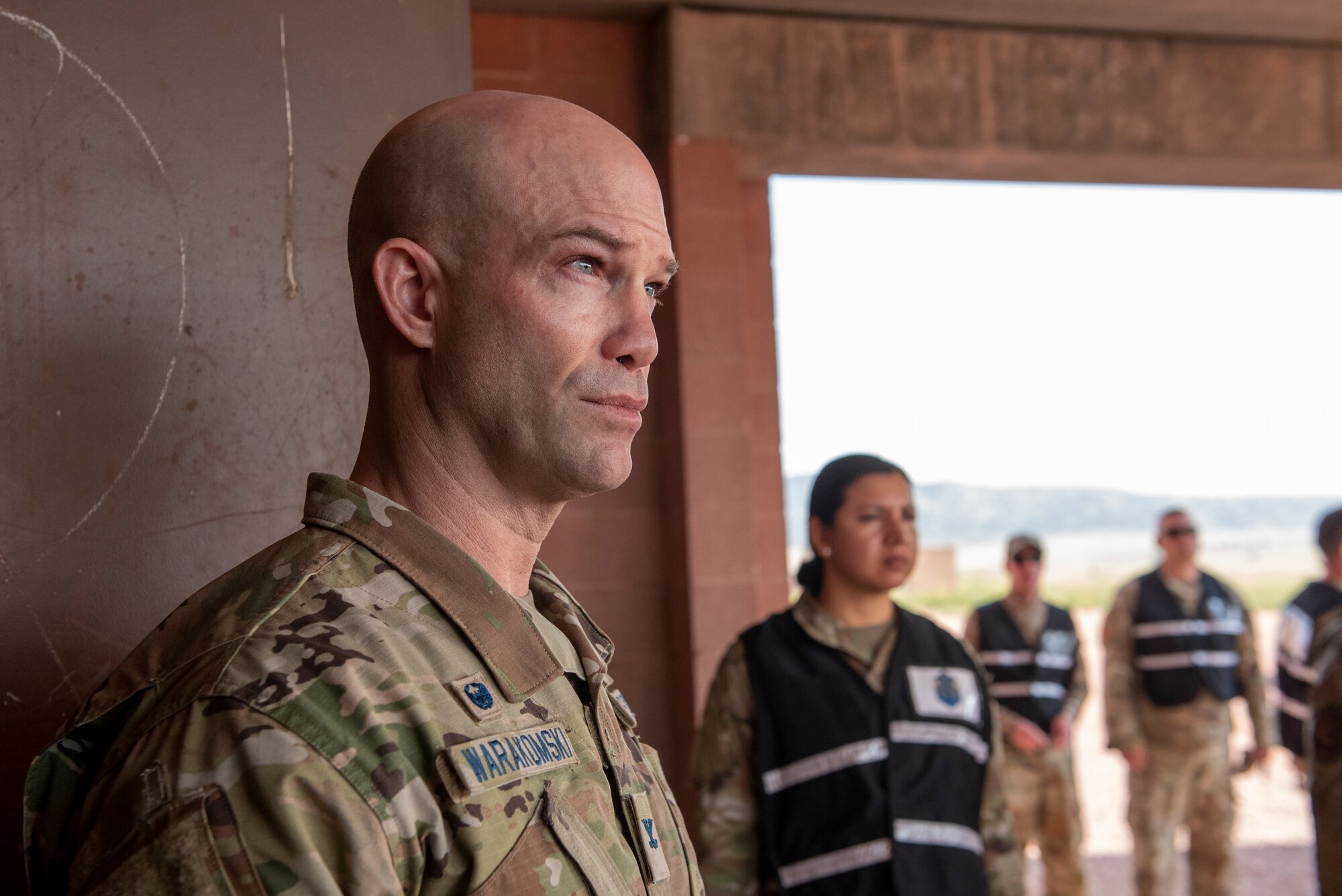 U.S. Space Force Col. Shay Warakomski, Peterson-Schriever Garrison commander, speaks with airmen Airmen and Guardians participating in the chemical, biological, radiological and nuclear defense exercise at Camp Red Devil on Fort Carson, Colorado, Aug. 18, 2021. In order to remain proficient in CBRN threats, hazards and procedures, Airmen and Guardians are tested on these procedures which include recognizing CBRN alarms and signals and how to properly don protective clothing during an attack. (U.S. Space Force photo by Airman 1st Class Kaitlin Castillo)