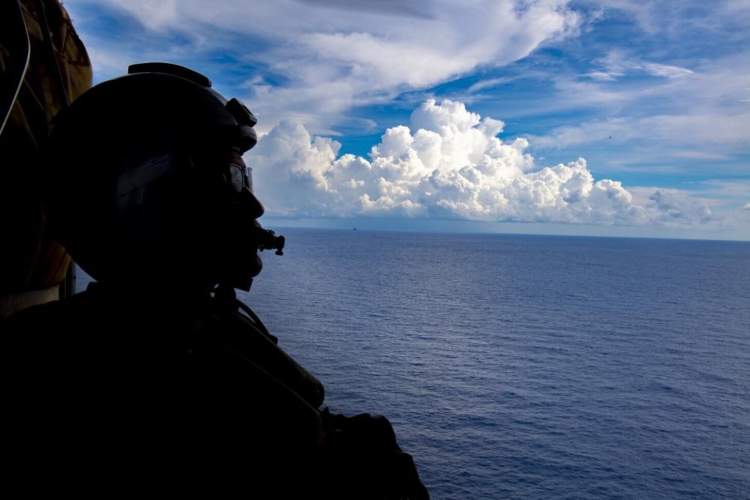 Naval Aircrewmen (Helicopter) 2nd Class Nicolas Lopez from Artesia, Calif., keeps a lookout during flight operations inside of a MH-60S Seahwak helicopter assigned to the “Blackjacks” of Helicopter Sea Combat Squadron (HSC) 21 aboard the Independence-variant littoral combat ship USS Tulsa (LCS 16), Aug. 27, 2021.