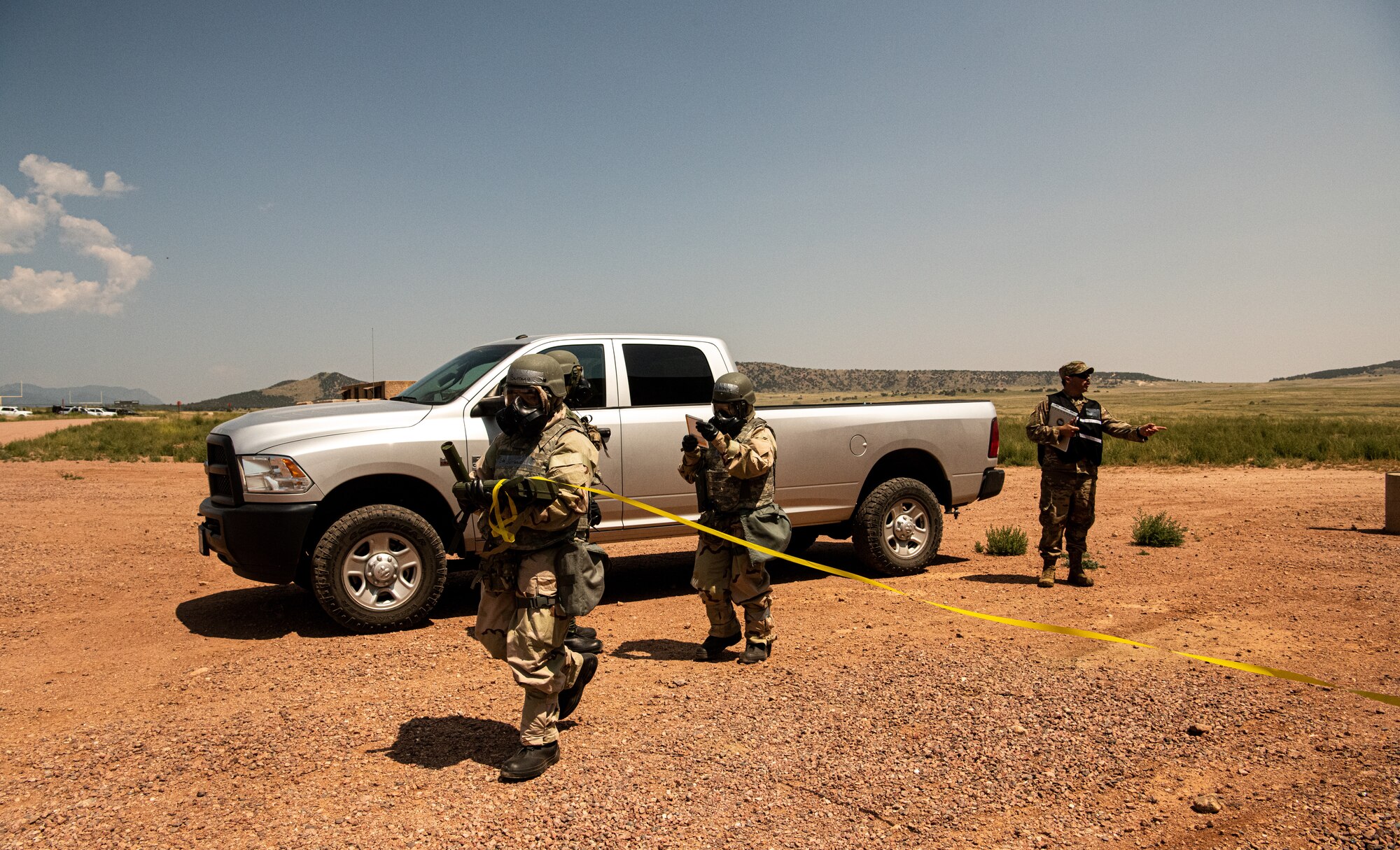 FORT CARSON, Colo.--Participants in a CBRN exercise wrap tape around a contaminated area at Fort Carson, Colorado, Aug. 18 2021. The exercise allows members to practice the use of all hazard detection equipment, personal protective equipment, hazardous scene sample collection and operational decontamination. (U.S. Space Force photo by Airman 1st Class Joshua Fontenot)