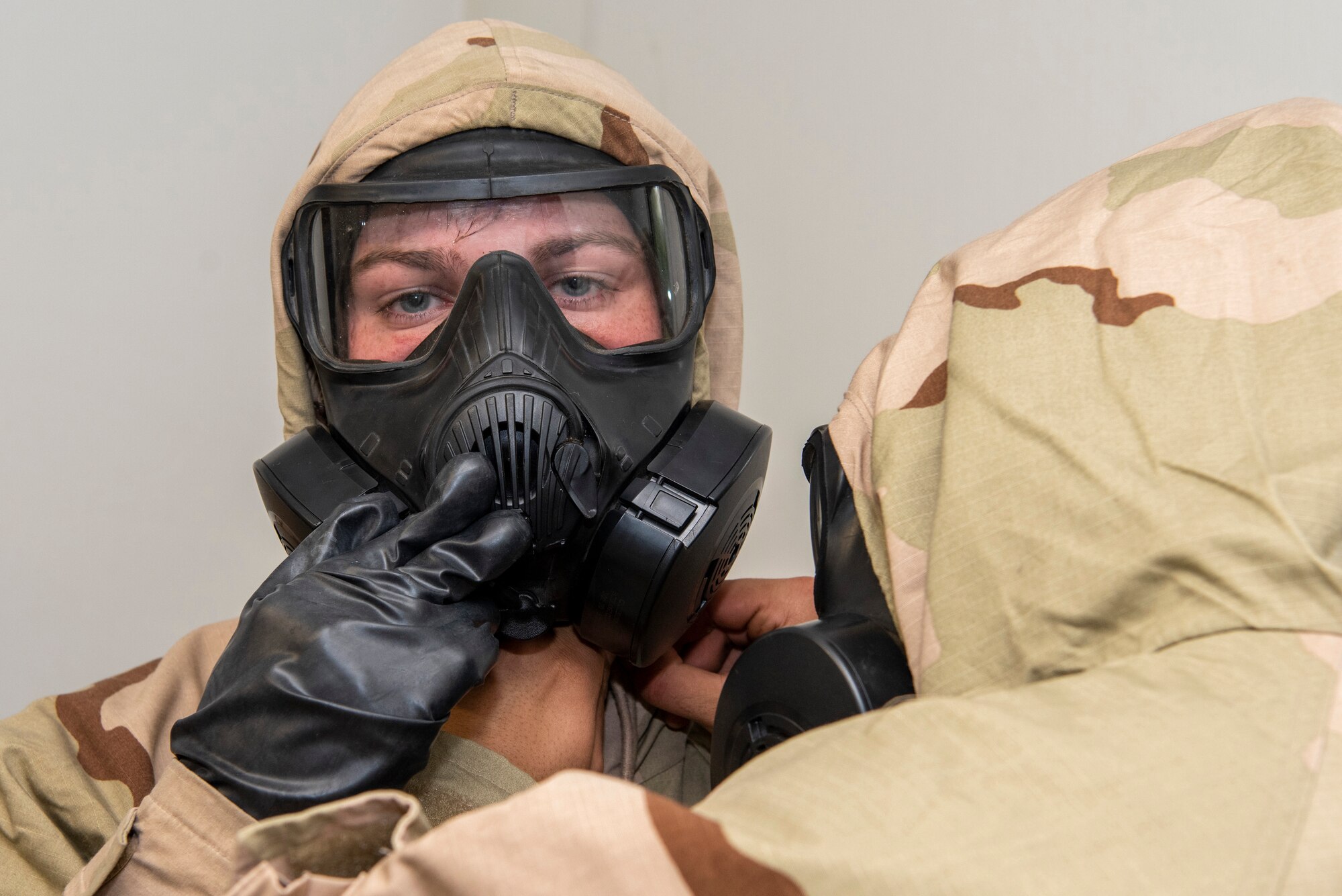 A U.S. Army paratrooper assigned to the 1st Battalion, 501st Parachute Infantry Regiment, 4th Infantry Brigade Combat Team (Airborne), 25th Infantry Division, U.S. Army Alaska, dons Joint Service Lightweight Integrated Suit Technology during the Chemical, Biological, Radiological and Nuclear defense station at Joint Base Elmendorf-Richardson, Alaska, Aug. 26, 2021. Soldiers assigned to the 4/25th IBCT completed various stations for a best squad competition. (U.S. Air Force photo by Senior Airman Emily Farnsworth)