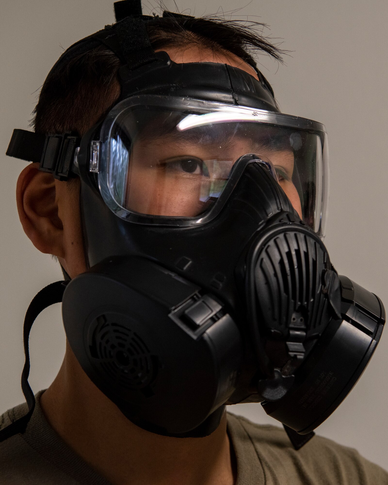 U.S. Army Pfc. Tony Chu, a combat medic assigned to Headquarters and Headquarters Troop, 1st Squadron (Airborne), 40th Cavalry Regiment, 4th Infantry Brigade Combat Team (Airborne), 25th Infantry Division, U.S. Army Alaska, watches Chemical, Biological, Radiological and Nuclear defense training while exposed to non-lethal o-Chlorobenzylidene malononitrile (CS) gas at Joint Base Elmendorf-Richardson, Alaska, Aug. 26, 2021. Chu was a medic at the CBRN defense station during the 4/25th IBCT best squad competition. (U.S. Air Force photo by Senior Airman Emily Farnsworth)