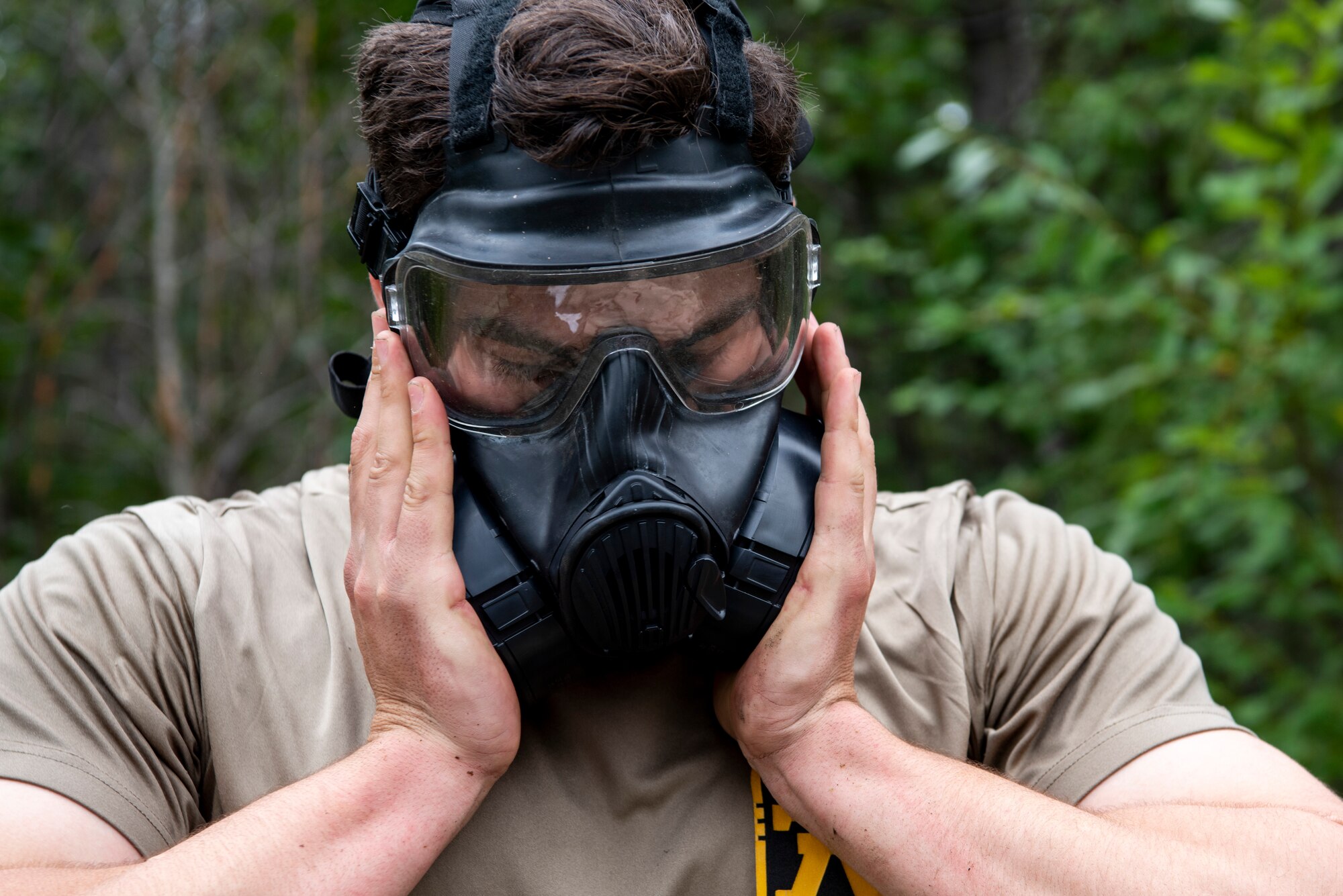 A U.S. Army Soldier assigned to the 3rd Battalion, 509th Parachute Infantry Regiment, 4th Infantry Brigade Combat Team (Airborne), 25th Infantry Division, U.S. Army Alaska, dons his M50 Joint Service General Purpose Mask before entering the Chemical, Biological, Radiological and Nuclear defense station at Joint Base Elmendorf-Richardson, Alaska, Aug. 26, 2021. Soldiers assigned to the 4/25th IBCT completed various stations for a best squad competition. (U.S. Air Force photo by Senior Airman Emily Farnsworth)