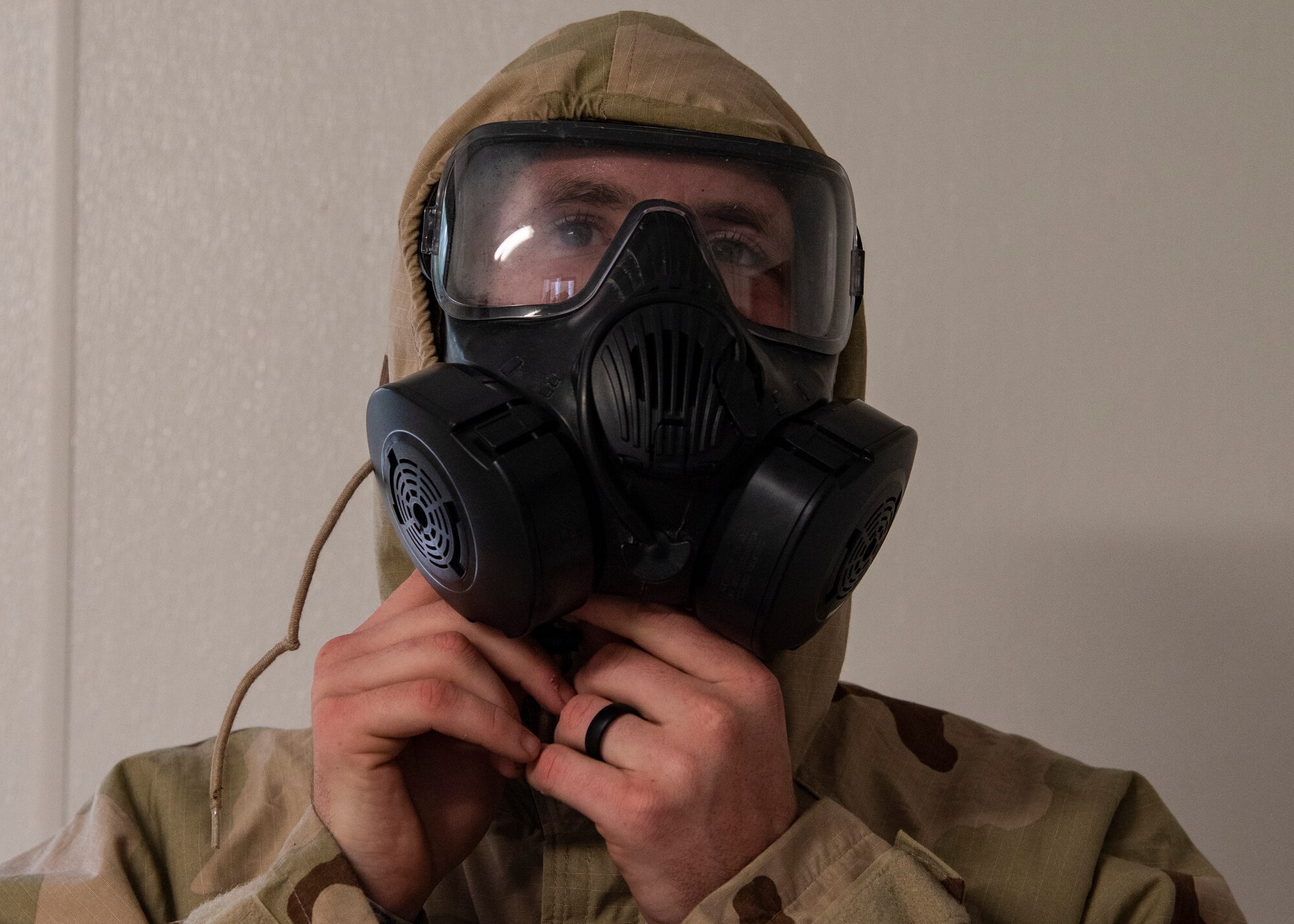 A U.S. Army paratrooper assigned to the 3rd Battalion, 509th Parachute Infantry Regiment, 4th Infantry Brigade Combat Team (Airborne), 25th Infantry Division, U.S. Army Alaska, dons Joint Service Lightweight Integrated Suit Technology during the Chemical, Biological, Radiological and Nuclear defense station at Joint Base Elmendorf-Richardson, Alaska, Aug. 26, 2021. Soldiers assigned to the 4/25th IBCT completed various stations for a best squad competition. (U.S. Air Force photo by Senior Airman Emily Farnsworth)