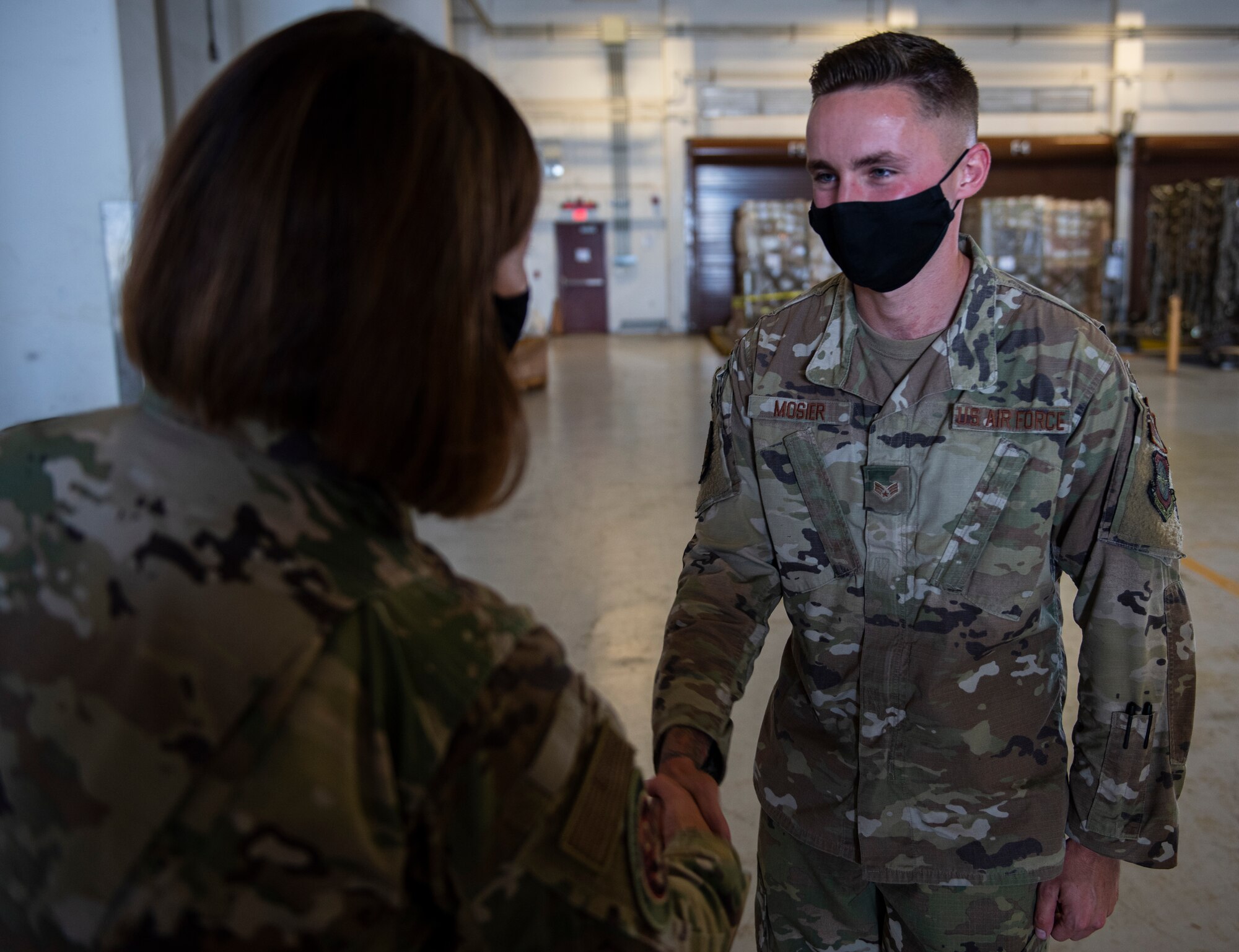 Chief Master Sergeant of the Air Force JoAnne S. Bass coins Senior Airman Cody Mosier, an air terminal operations center information controller assigned to the 734th Air Mobility Squadron at Andersen Air Force Base, Guam, Aug. 27, 2021.