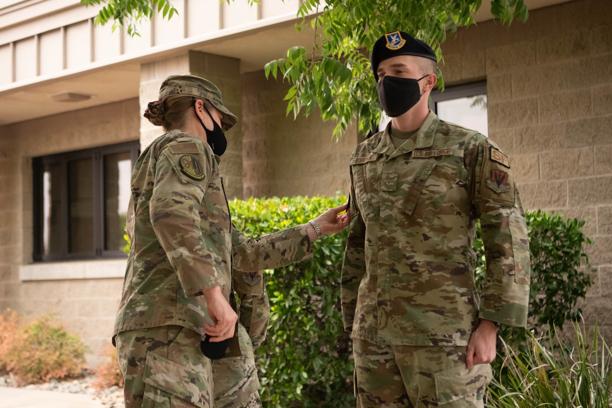 Col. Heather Fox, 9th Reconnaissance Wing commander, left, gives a patch to Airman Samuel Workman, 9th Security Forces Squadron installation entry controller, Aug. 18, 2021, at Beale Air Force Base, California.