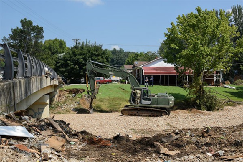 A large machine moves dirt during cleanup operations.