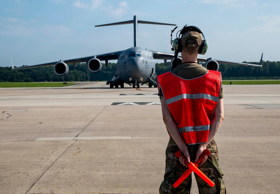 Airman 1st Class Tyler Davis, 736th Aircraft Maintenance Squadron crew chief, prepares to marshal a C-17 Globemaster III at Dover Air Force Base, Delaware, en route to support Afghanistan evacuation efforts, Aug. 24, 2021. Team Dover members donated infant formula, blankets and clothing in support of the safe evacuation of U.S. citizens, Special Immigrant Visa applicants and other vulnerable Afghans. (U.S. Air Force photo by Senior Airman Stephani Barge)