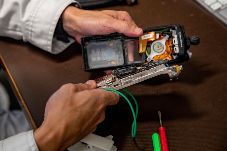 Hiroya Nakama, a master labor contractor with G-6 communications, Headquarters and Support Battalion, repairs an APX 6000 Motorola radio on Camp Foster, Okinawa, Japan, Aug. 18, 2021. Radio maintenance Marines ensure Marine Corps Installations Pacific first responders, and base dispatches consistently have working communication equipment throughout Okinawa by repairing or programming radios, and managing radio data. (U.S. Marine Corps photo by Lance Cpl. Jonathan A. Beauchamp)