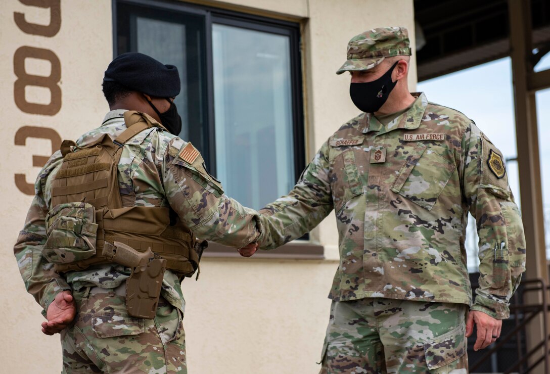 An Airman shakes hands with their chief.
