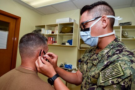 210823-N-PG340-1007 OKINAWA, Japan (Aug. 23, 2021) Lt. Jeffrey Moy (right), Naval Mobile Construction Battalion (NMCB) 5’s medical officer, administers battlefield auricular acupuncture (BFA) therapy to Cmdr. Andrew Olsen, NMCB-5’s commanding officer, onboard Camp Shields, Okinawa, Japan. NMCB-5 is the first U.S. Navy deployable command to perform BFA. The U.S. Navy Seabees with NMCB-5 are deployed, supporting a free and open Indo-Pacific by strengthening our network of allies and partners and providing general engineering and civil support to joint operational forces. Homeported out of Port Hueneme, California, NMCB-5 has 10 detail sites deployed throughout the U.S. and Indo-Pacific area of operations. (U.S. Navy photo by Mass Communication Specialist 1st Class Stephane Belcher/Released)