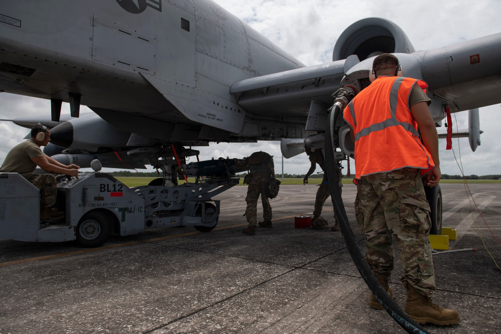A photo of Airmen standing under and next to an A-10C Thunderbolt too.