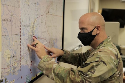 Cpt. Russell Parman of the Alabama National Guard's 711th Combat Sustainment Support Battalion adds dots to a map tracking road closures and incidents due to Hurricane Ida.