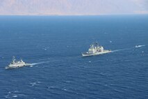 210831-N-WQ732-2166 GULF OF AQABA (August 31, 2021) – Israeli Navy corvette INS Eilat (501), left, guided-missile cruiser USS Monterey (CG 61), center, and an Israeli Navy fast patrol boat transit in formation during a combined maritime security patrol in the Gulf of Aqaba, Aug. 31. Monterey is deployed to the U.S. 5th Fleet area of operations in support of naval operations to ensure maritime stability and security in the Central Region, connecting the Mediterranean and Pacific through the western Indian Ocean and three strategic choke points. (U.S. Navy photo by Naval Air Crewman 2nd Class Jesse Johnston)