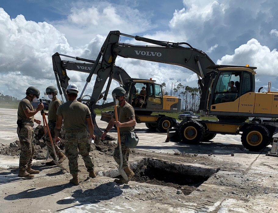 Airmen remove debris around runway crater