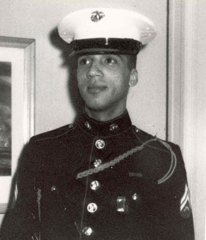 A young man wears the Marine Corps dress uniform with cap.