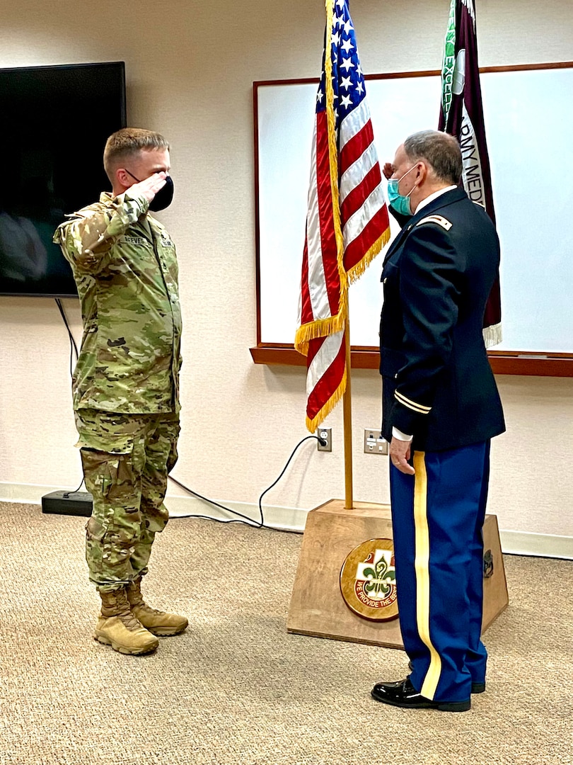 Staff Sgt. Cameron Reeves (left) renders the first salute to newly commissioned U.S. Army Reservist, Maj. Peter Edelstein, medical doctor and general surgeon, during a ceremony at Bayne-Jones Army Community Hospital Aug. 27.