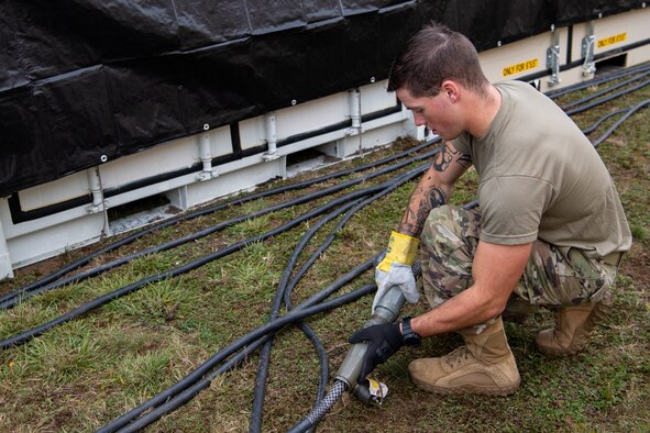 Airman installs electricity to pod.