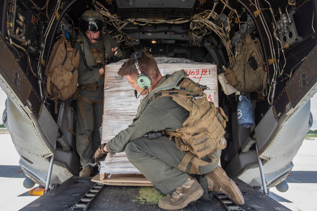 United States Marines with Marine Medium Tiltrotor Squadron 266, 2nd Marine Aircraft Wing, II Marine Expeditionary Force, load cases of food into an MV-22B Osprey in support of Joint Task Force-Haiti for a humanitarian assistance and disaster relief mission in Port-au-Prince, Haiti, Aug. 27, 2021. (U.S. Marine Corps photo by Cpl. Yuritzy Gomez)