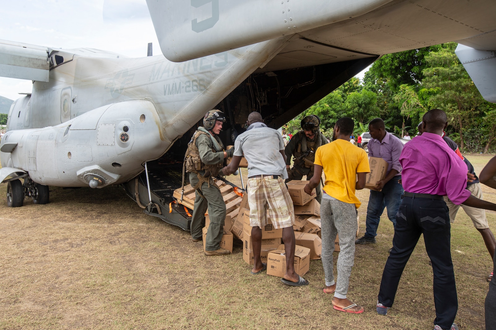 United States Marines with Marine Medium Tiltrotor Squadron 266, 2nd Marine Aircraft Wing, II Marine Expeditionary Force, deliver cases of food in support of Joint Task Force-Haiti for a humanitarian assistance and disaster relief mission in Les Anglais, Haiti, Aug. 27, 2021. (U.S. Marine Corps photo by Cpl. Yuritzy Gomez)