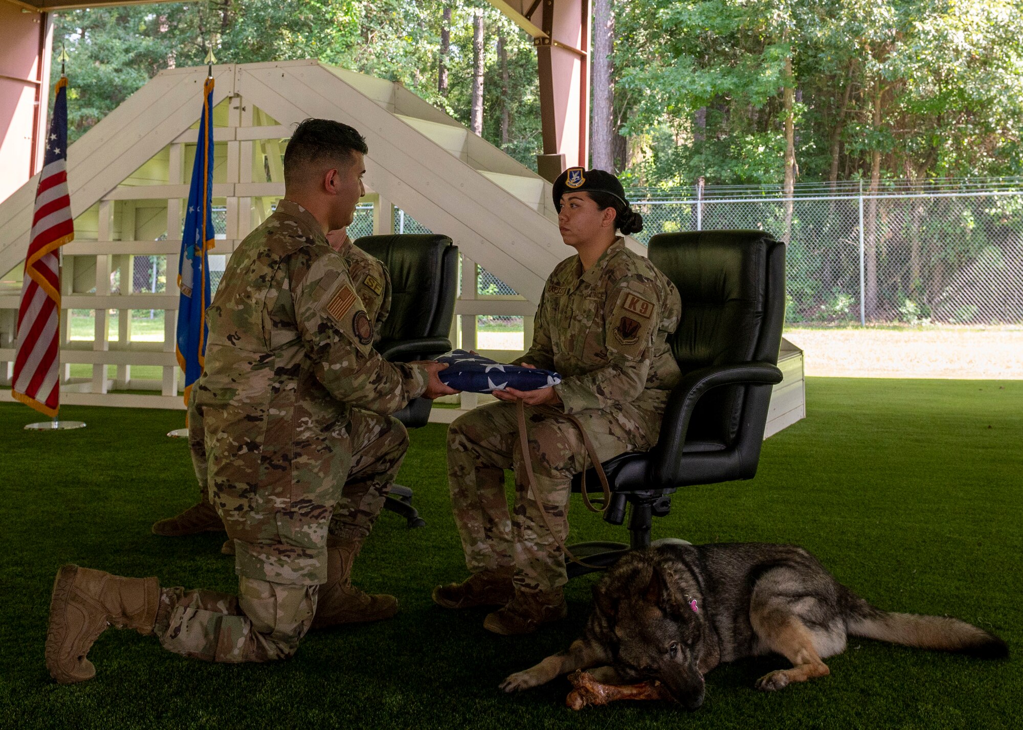 Staff Sgt. Maegan-Ann Baptista, right, 4th Security Forces Squadron military working dog handler, receives a folded American flag from Senior Airman Hector Saenz, 4th Force Support Squadron honor guardsman, during MWD Gina’s retirement ceremony at Seymour Johnson Air Force Base, North Carolina, Aug. 26, 2021.