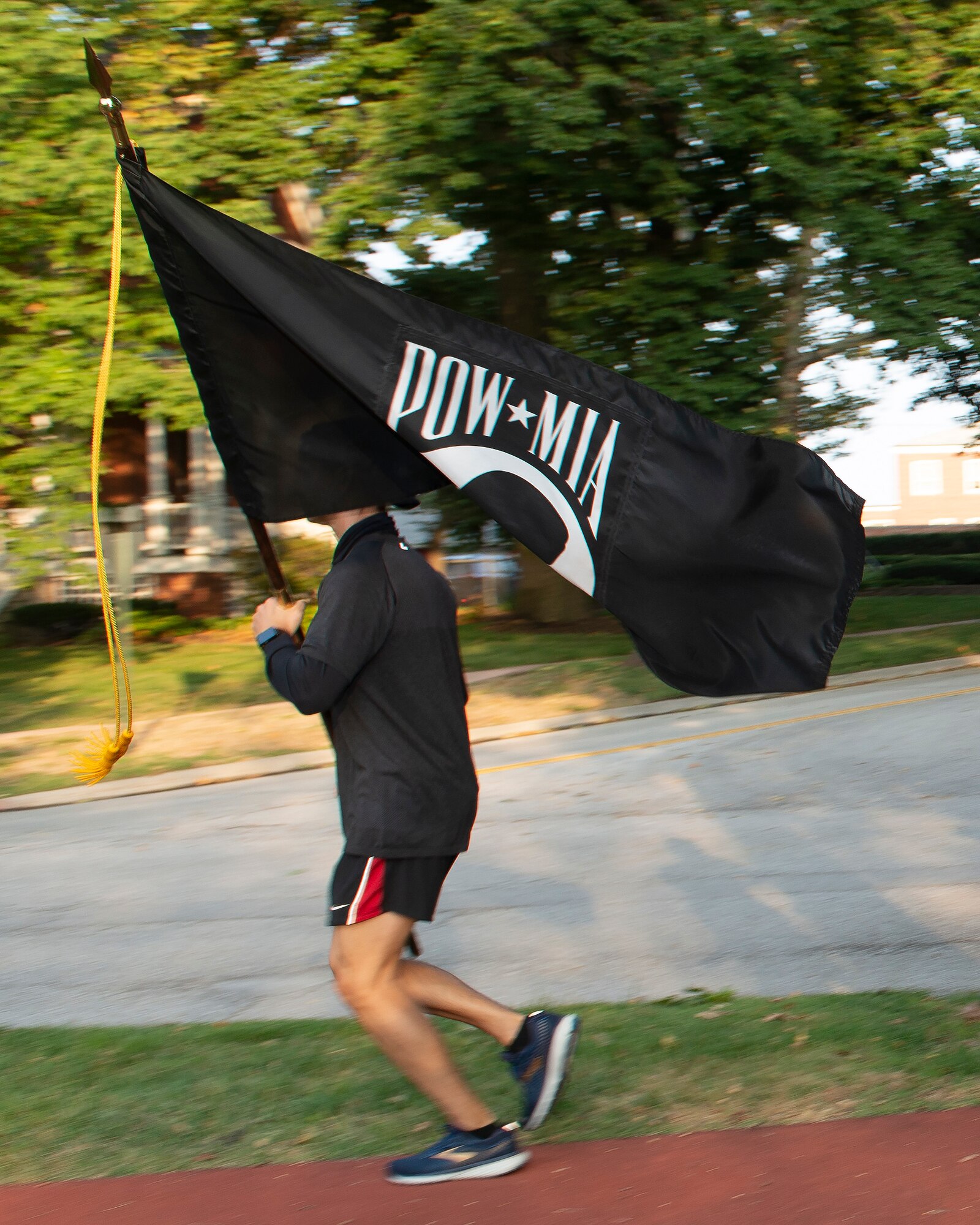 airman running while carrying a POW/MIA flag