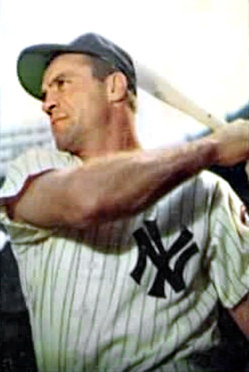 A baseball player holds a bat.