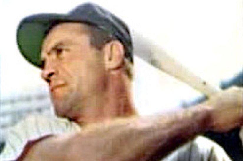 A baseball player holds a bat.