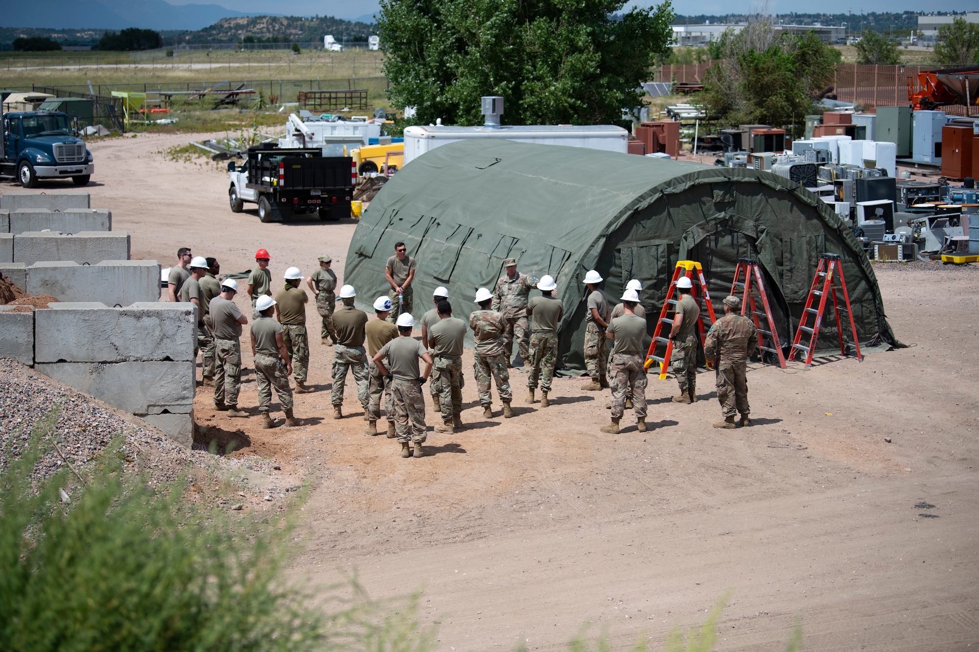 People stand outside of tent.