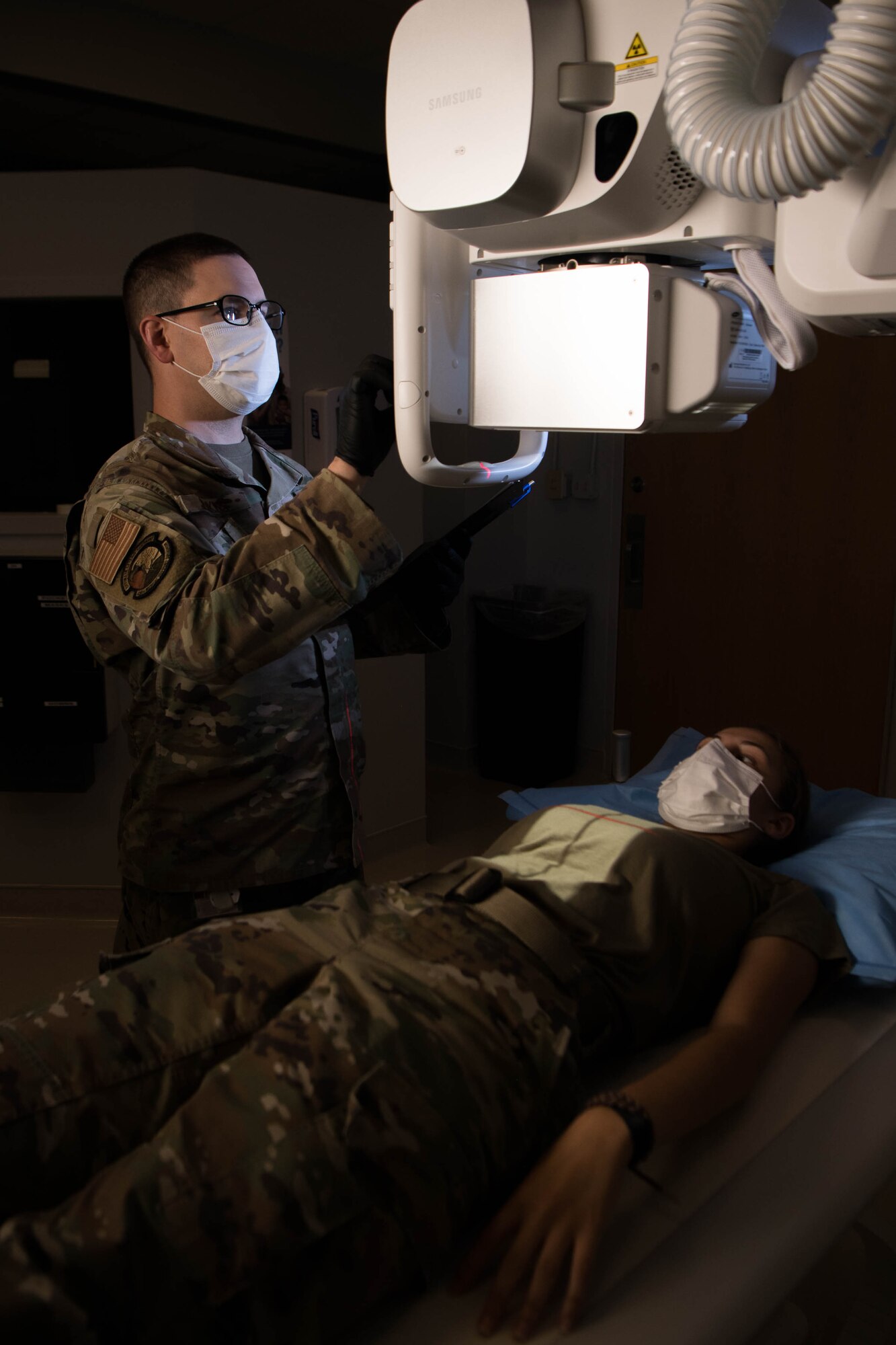 Tech. Sgt. Timothy Jenkins, 436th Medical Support Squadron Diagnostic Imaging section chief, prepares to take a thoracic spine X-ray of Airman 1st Class Brianna Monteiro, 436th MDSS medical laboratory technician, on Dover Air Force Base, Delaware, Aug. 13, 2021. Radiology Airmen assigned to Dover AFB serve a three-year controlled tour to enable full support of the Armed Forces Medical Examiner System mission. (U.S. Air Force photo by Mauricio Campino)