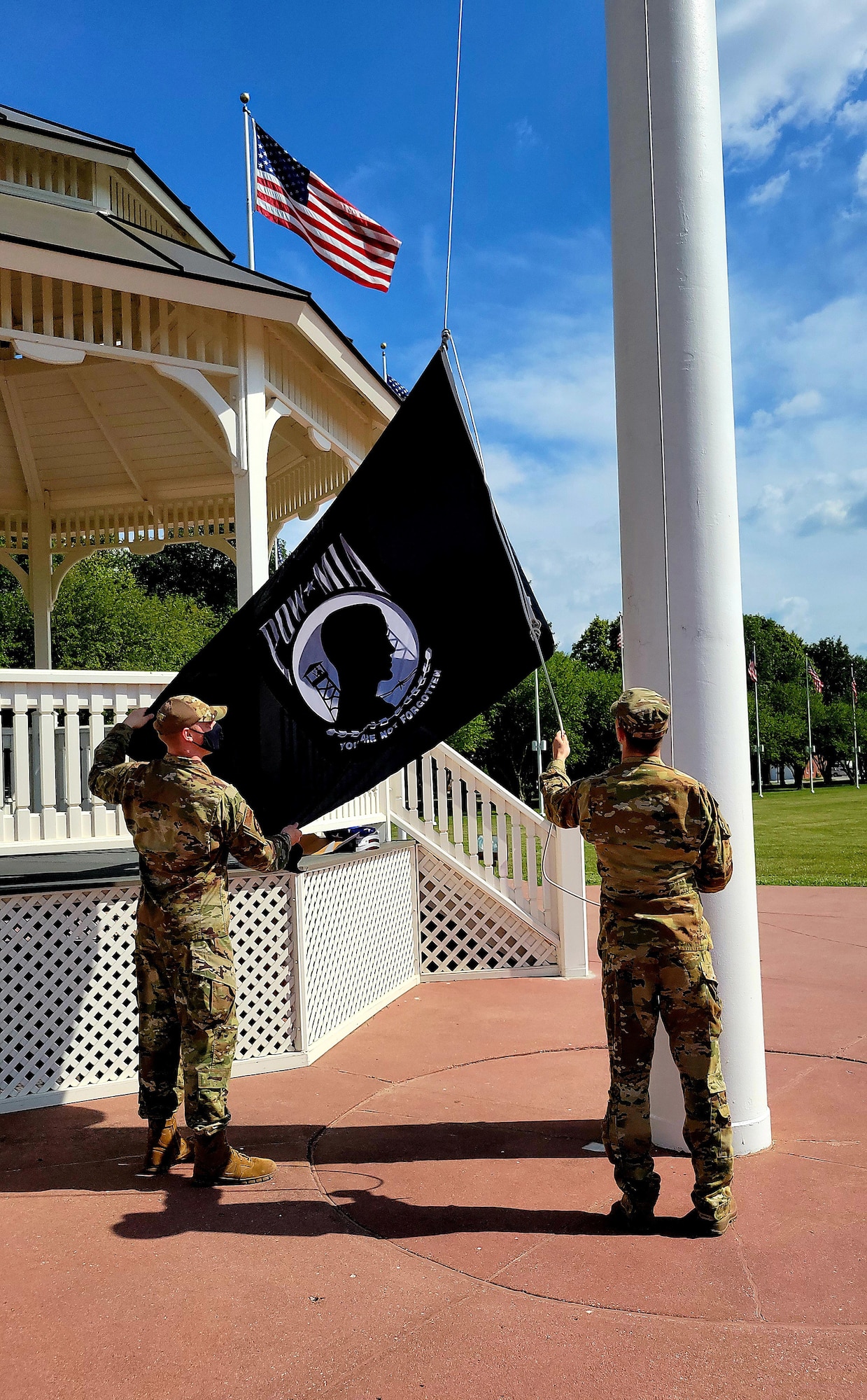 Two Airmen raising POW/MIA flag on flag pole